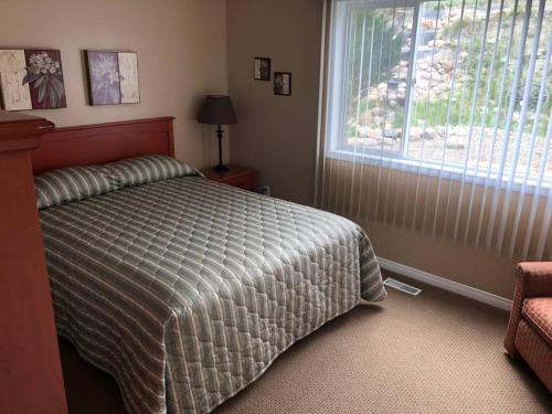 - une chambre avec un lit et une grande fenêtre dans l'établissement Paradise Canyon Golf Resort - Luxury Condo M405, à Lethbridge
