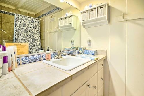 a bathroom with a sink and a mirror at Tropical Paniolo Hale Townhome, Walk to Beach in Maunaloa