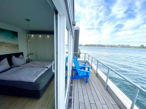 a bedroom and bed on a boat on the water at Schwimmendes Haus Sea Breeze in Olpenitz