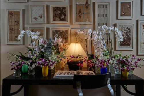 a table with vases of flowers on it at Casa Howard Firenze - Residenza d'Epoca in Florence