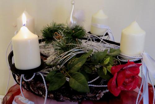 a table with three candles and plants on it at Pension Krakolinig in Pörtschach am Wörthersee