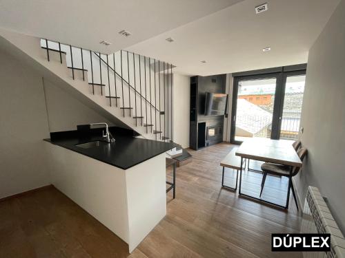 una cocina con fregadero y una escalera en una casa en Apartaments Cal Bertran, en Bellver de Cerdanya 