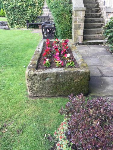 a stone planter with flowers in the grass at Wellington Inn in Harrogate