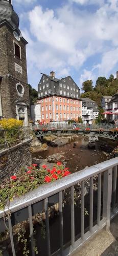 a town with a river with flowers and a clock tower at Ferienhaus Eifelherz in Simmerath