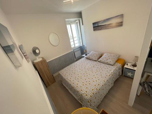 une petite chambre avec un lit et un miroir dans l'établissement Appt FOURAS Centre Ville 50m de la Mer, à Fouras
