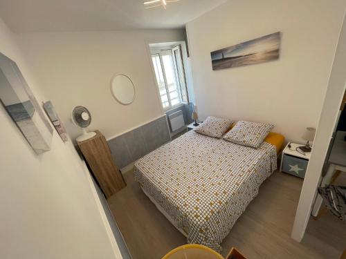 a small bedroom with a bed and a mirror at Appt FOURAS Centre Ville 50m de la Mer in Fouras