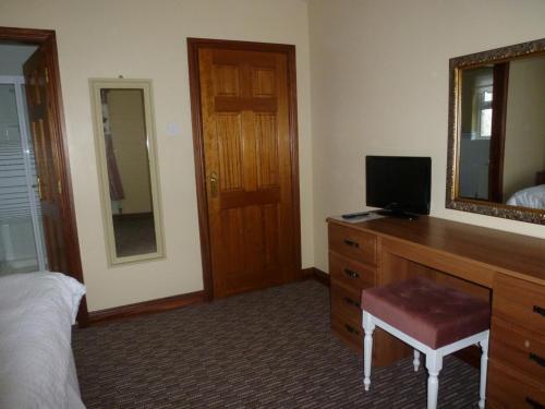 a bedroom with a dresser with a mirror and a bed at Edenroe in Dungiven