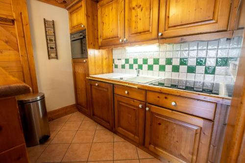 a kitchen with wooden cabinets and a sink at Daguet 1D6 in Les Allues