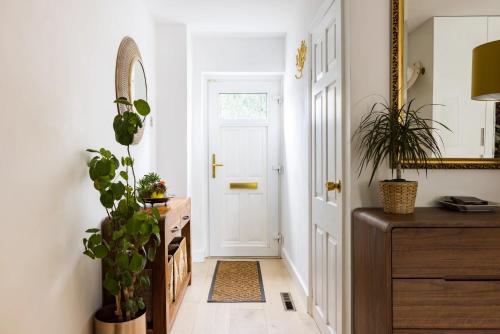 a hallway with a white door and a mirror at En-suite luxury large bedroom with parking and two tickets to Kew Gardens in Kew Gardens