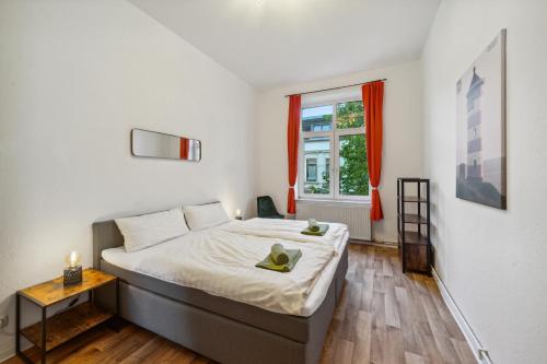 a bedroom with a large bed and a window at Infinity Stay: Bis zu 4 Personen Zentrum Wassernah Netflix in Wilhelmshaven