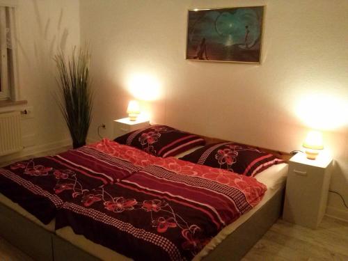 a bedroom with a bed with two lights on at Apartment 1 Langelsheim Harz in Langelsheim
