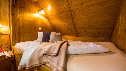 um quarto com uma cama num chalé de madeira em Gästehaus Holzer Kreuz -Ferienwohnung "Kornblume" em Fröhnd