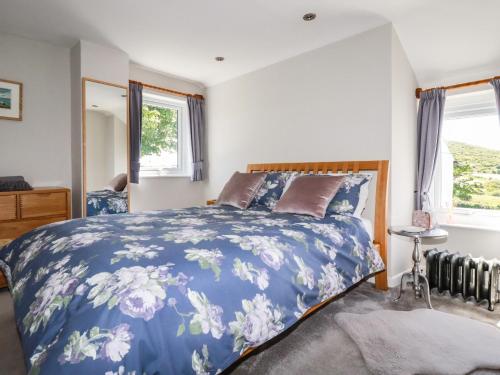 セント・アイヴスにあるSanctuary Cottageのベッドルーム(青と白のベッド1台、窓付)