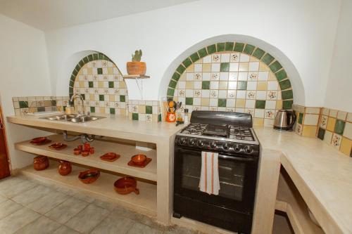 a kitchen with a stove and a sink at Cien Palmas- Authentic Mexican Casita 1 -Downtown in Todos Santos