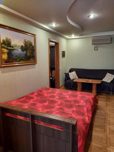 a bedroom with a large red bed and a table at Irina HOME in Kyiv
