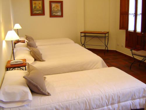 Ένα ή περισσότερα κρεβάτια σε δωμάτιο στο El Arribo Hotel