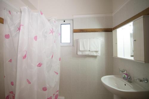 a bathroom with a shower curtain with pink hearts on it at Kalithea Apartments (heated pool) in Kalyves