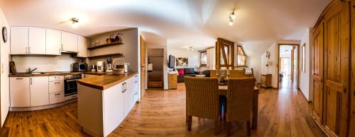 a kitchen with white cabinets and a wooden floor at Gästehaus Holzer Kreuz - Ferienwohnung "Mohn" in Fröhnd