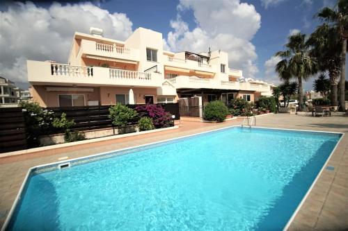 uma piscina em frente a uma casa em Central Pool-Side 2 Bedroom Apartment in Paphos em Pafos