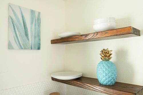 a bathroom with a toilet and a vase on a shelf at Casa Limonada Boutique Motel in Sarasota