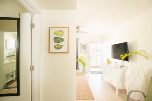 a white room with a television and a dining room at Casa Limonada Boutique Motel in Sarasota