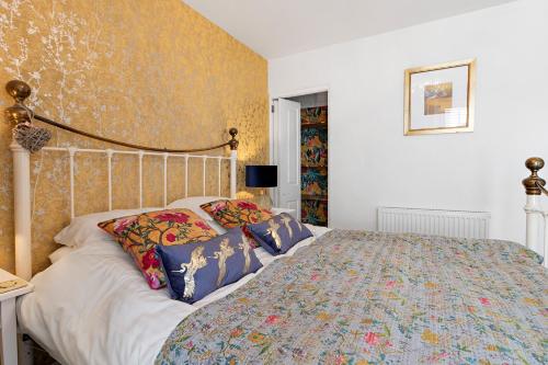 a bedroom with a bed with a floral bedspread at Hope Cottage, Brixham in Brixham