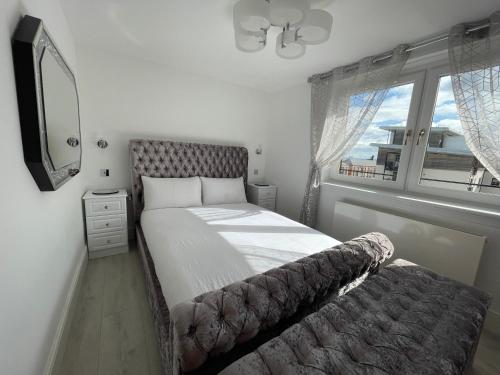 um quarto com uma cama, um espelho e uma janela em Flat On The Shore em Edinburgo