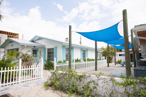 a house with a white fence and a blue flag at Casa Limonada Boutique Motel in Sarasota