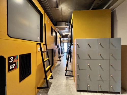 a locker room with lockers and a yellow wall at Icon Hotel Hatyai in Hat Yai