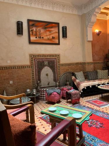 a living room with a table and a fireplace at Dar Pa Labzioui in Meknès