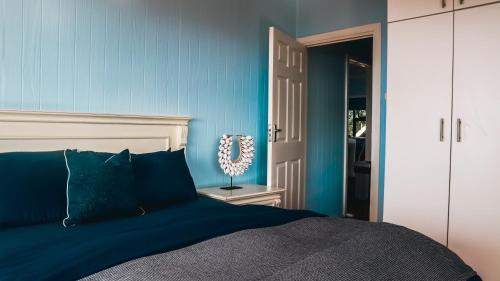a bedroom with a bed with a blue wall at Campismo Ninho Villa 26 - Ponta Malongane in Ponta Malongane