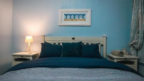 a blue bedroom with a bed with blue walls at Campismo Ninho Villa 26 - Ponta Malongane in Ponta Malongane