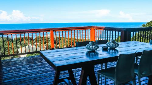 a wooden table with vases on a deck with the ocean at Campismo Ninho Villa 26 - Ponta Malongane in Ponta Malongane