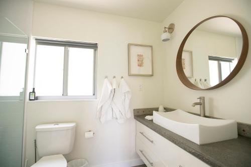 a white bathroom with a sink and a mirror at Casa Limonada Boutique Motel in Sarasota