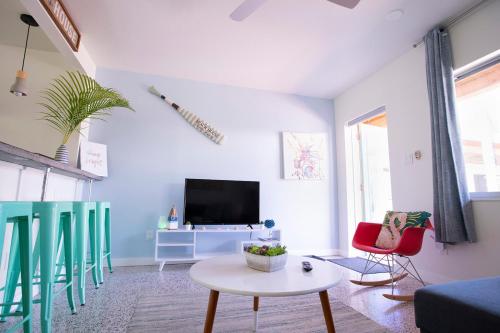 a living room with blue and white walls and a tv at Casa Limonada Boutique Motel in Sarasota