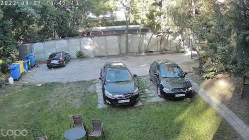 three cars parked in a yard next to a fence at JUNA - nowoczesny apartament w centrum z widokiem na park in Pruszków