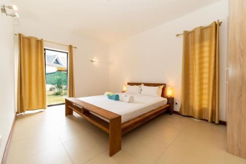 a bedroom with a bed and a large window at Tropical Villa by Fabular Villas & Hotels in Rivière Noire
