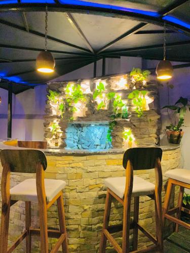 a bar with two chairs and a stone wall with plants at Hotel ABC, Boutique Hotel in Pokhara in Pokhara
