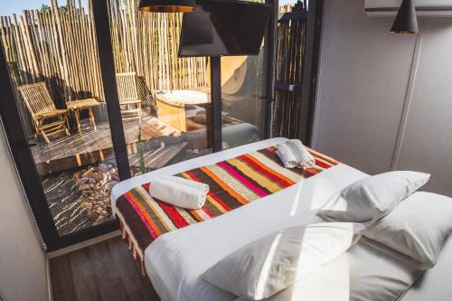a bedroom with a bed and a view of a balcony at Quisquito Lodge & Spa - Punta de Lobos - Tina 24 Hrs in Pichilemu