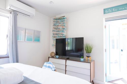 a bedroom with a flat screen tv on a dresser at Casa Limonada Boutique Motel in Sarasota