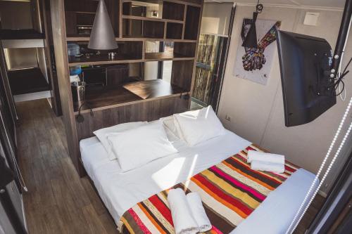 a small bedroom with a bed with towels on it at Quisquito Lodge & Spa - Punta de Lobos - Tina 24 Hrs in Pichilemu