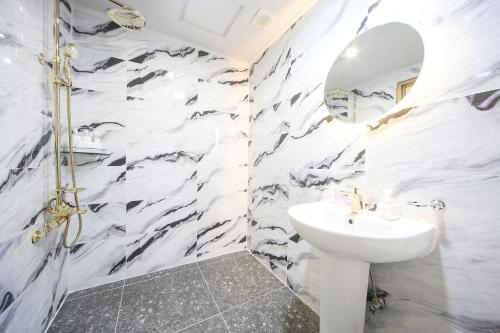 a white bathroom with a sink and a mirror at Masan First Class Hotel in Changwon