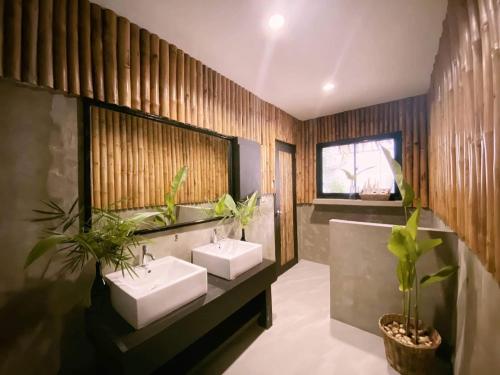 a bathroom with two sinks and two mirrors at Lio Villas Resort in El Nido