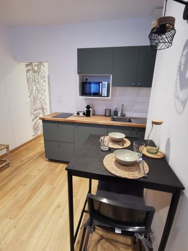 une cuisine avec une table avec des chaises et un micro-ondes dans l'établissement Charmant studio Bayeux centre ville historique, à Bayeux