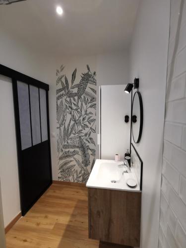 une salle de bain avec un lavabo et un miroir dans l'établissement Charmant studio Bayeux centre ville historique, à Bayeux