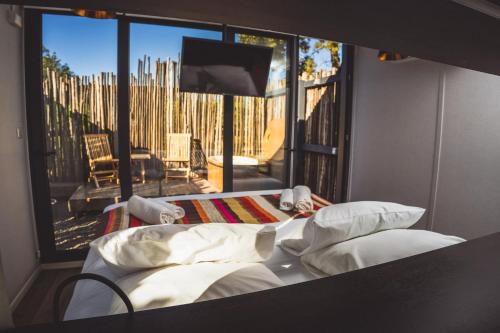 a bedroom with a bed and a view of a patio at Quisquito Lodge & Spa - Punta de Lobos - Tina 24 Hrs in Pichilemu