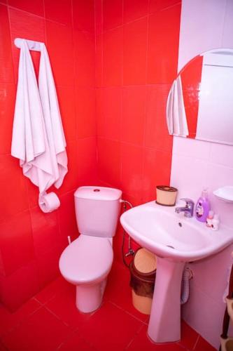 a red bathroom with a toilet and a sink at Lucky 2 in Pavel Banya