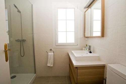 a bathroom with a shower and a sink and a mirror at Cove Noves - Relax en Menorca, Ideal para familias in Punta Grossa