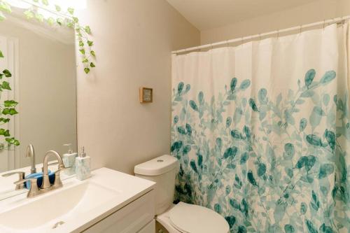 a bathroom with a toilet and a shower curtain at Cozy Family Retreat with Arcade, Grill, Waffle Bar & Firepit in Norcross