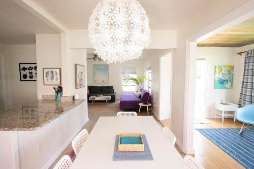 a dining room and living room with a chandelier at Casa Limonada Boutique Motel in Sarasota